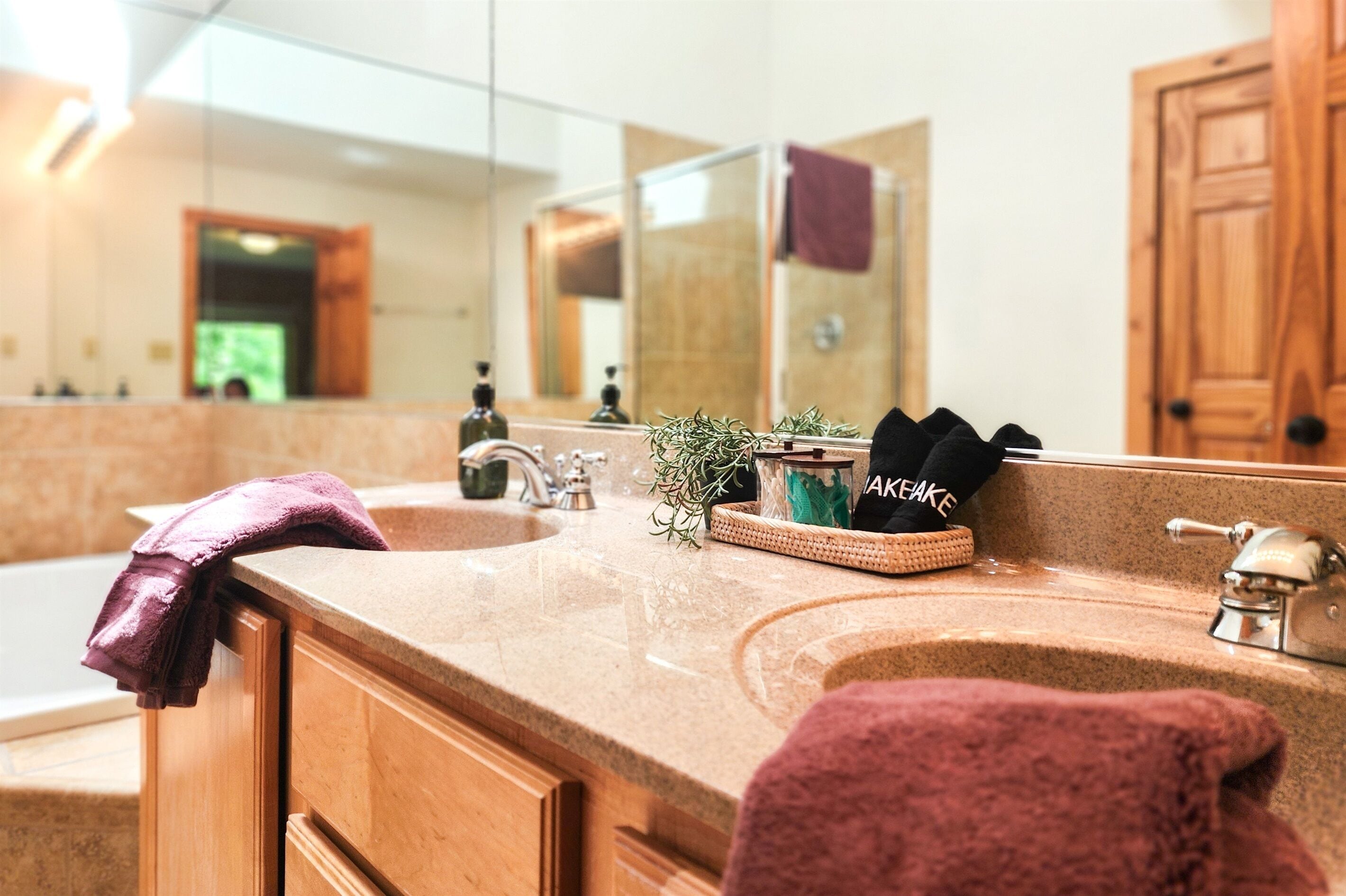 A bathroom with a sink, mirror, and wooden cabinets.
