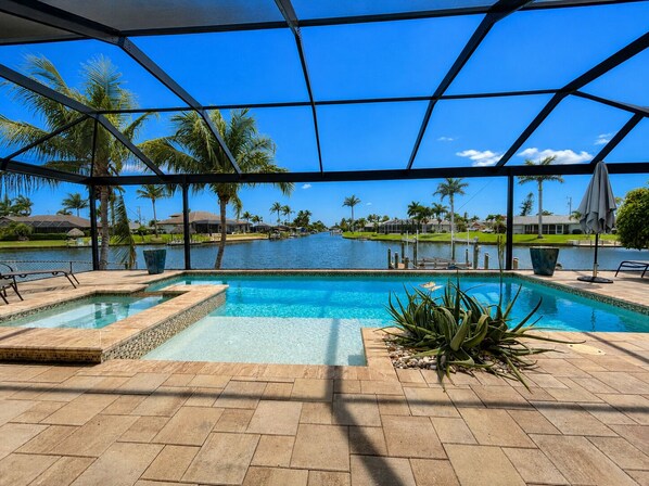 Una piscina con vista a un cuerpo de agua y palmeras.