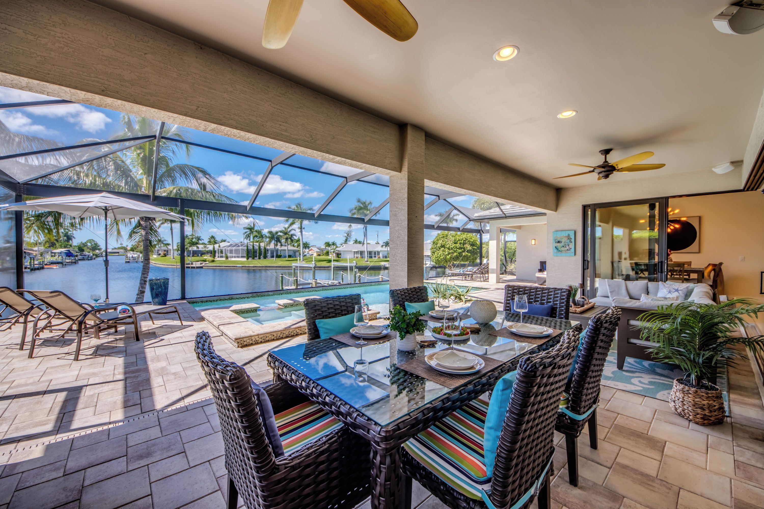 A covered outdoor area with a glass enclosure, a pool, and seating arrangements.