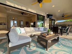 Ein modernes Wohnzimmer mit einer Couch, einem Couchtisch und Deckenventilatoren.