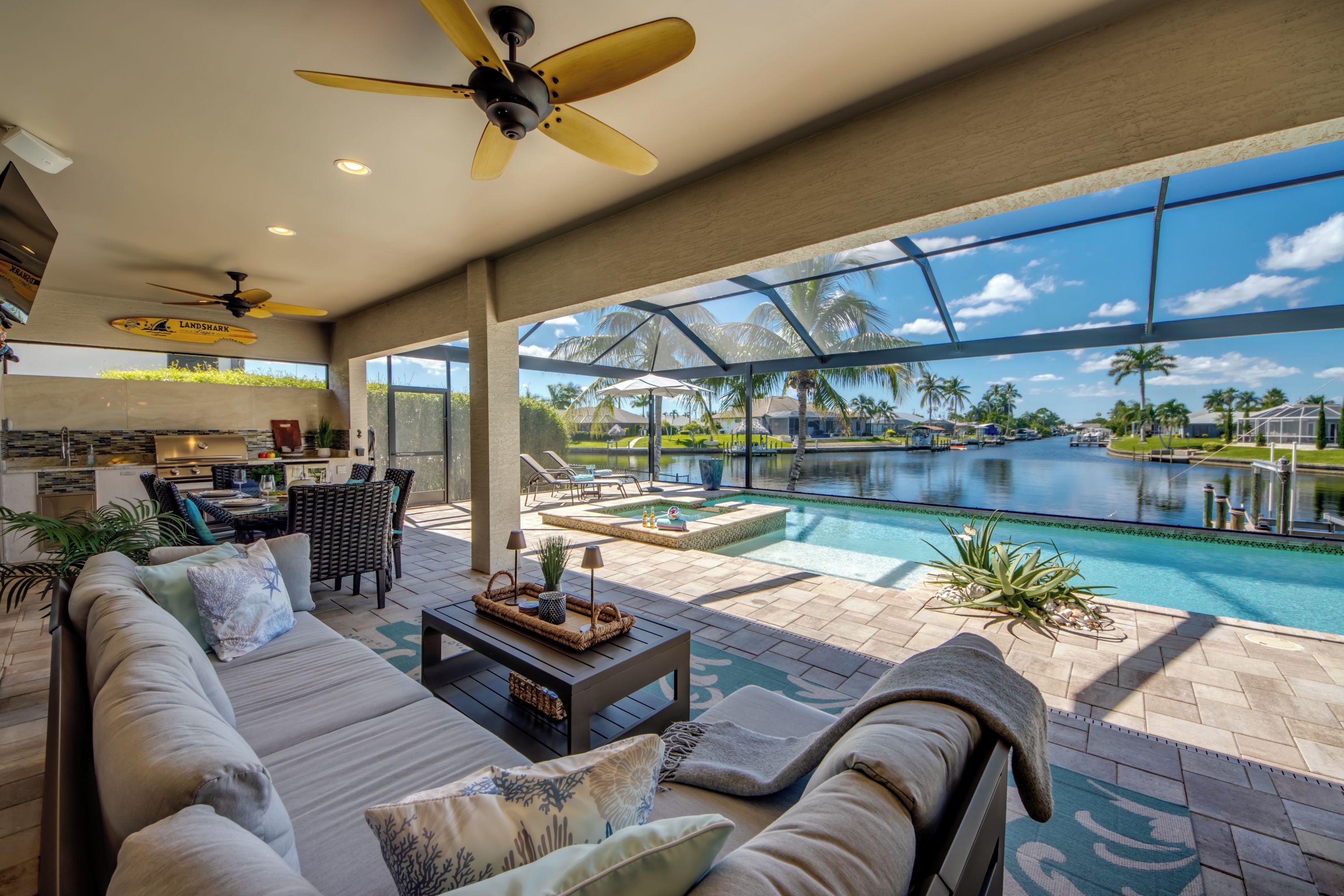 A spacious outdoor area with a pool, seating, and a view of the water.