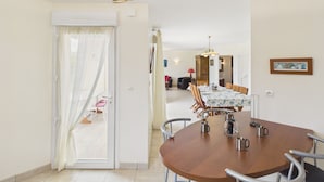 A dining area with a round table, chairs, and a hanging light fixture. - Beach at 200m, family house for 7 with garden (Plouguerneau)