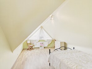 A bedroom with a bed, a chair, a desk, and a window. - Near beach, spacious house with garden (Plouguerneau)