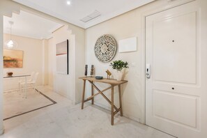 Ein Zimmer mit einem Holztisch, einer weißen Tür und einem Wanddekor.