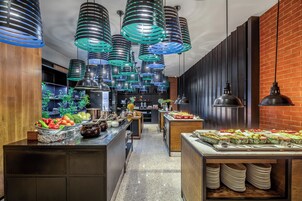 A modern kitchen with stainless steel appliances, wooden cabinets, and a brick wall.