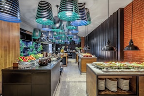 Una cocina moderna con electrodomésticos de acero inoxidable, armarios de madera y una pared de ladrillo.