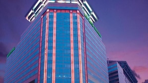A high-rise building with a modern glass facade and a prominent corner entrance. - Beijing New World Centre Tongpai Hotel (Beijing)