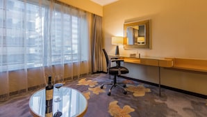 A hotel room with a glass table, a chair, a desk, a lamp, a mirror, and a window with sheer curtains. - Beijing New World Centre Tongpai Hotel (Beijing)