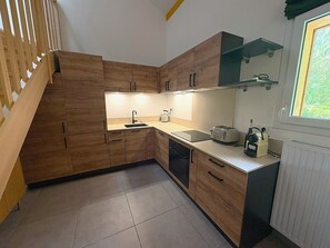 A modern kitchen with wooden cabinets, a sink, a toaster, and a window with a view. - REFLETS D'ARDENT 101  By Avecoeur (Montriond)