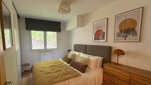 A bedroom with a bed, a dresser, a window, and two wall-mounted artworks. - REFLETS D'ARDENT 101  By Avecoeur (Montriond)