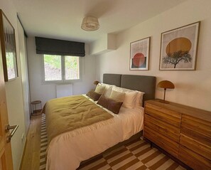 A bedroom with a bed, a dresser, a window, and two wall-mounted artworks. - REFLETS D'ARDENT 101  By Avecoeur (Montriond)