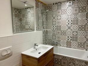 A bathroom with a white sink, wooden vanity, and a shower. - REFLETS D'ARDENT 101  By Avecoeur (Montriond)
