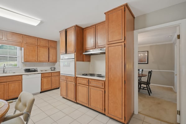 A kitchen with wooden cabinets, a white refrigerator, a stove, and a dishwasher. - NEW! Private Pool Oasis 15 mins to World Cup Sleeps 10 (Decatur)