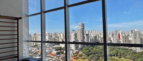 A room with large windows offering a view of a cityscape and a river.