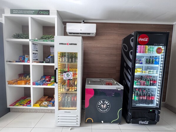A vending machine with ice cream and a Coca-Cola refrigerator. - Walk Bueno (Goiânia)