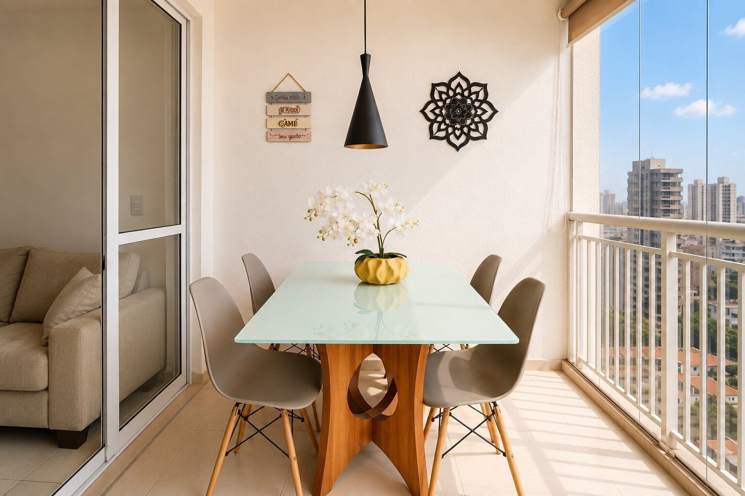 Ein Balkon mit Essbereich, einer Couch, einer Pendelleuchte und Wanddekoration.