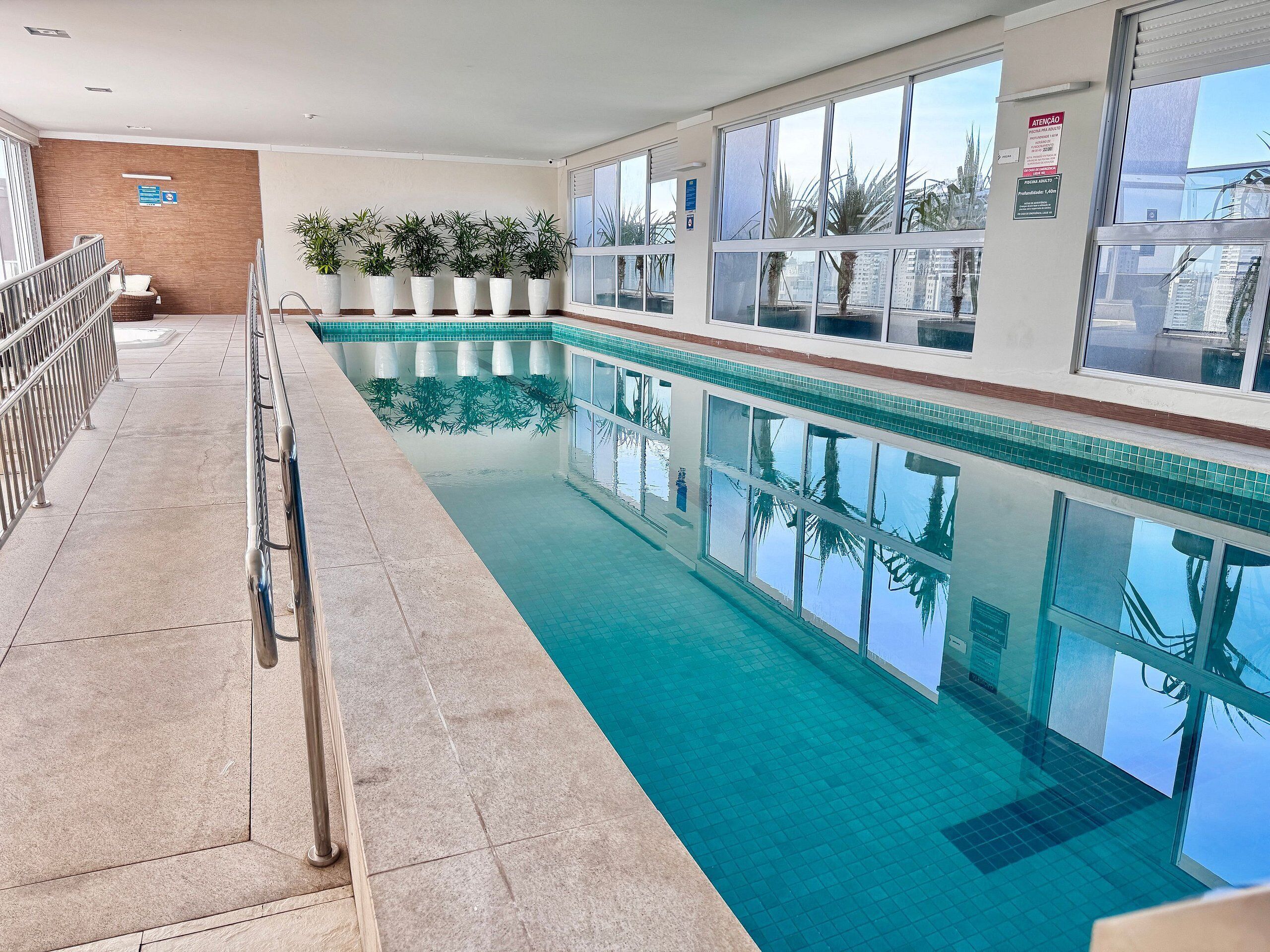 Una piscina al aire libre, sillones reclinables de piscina