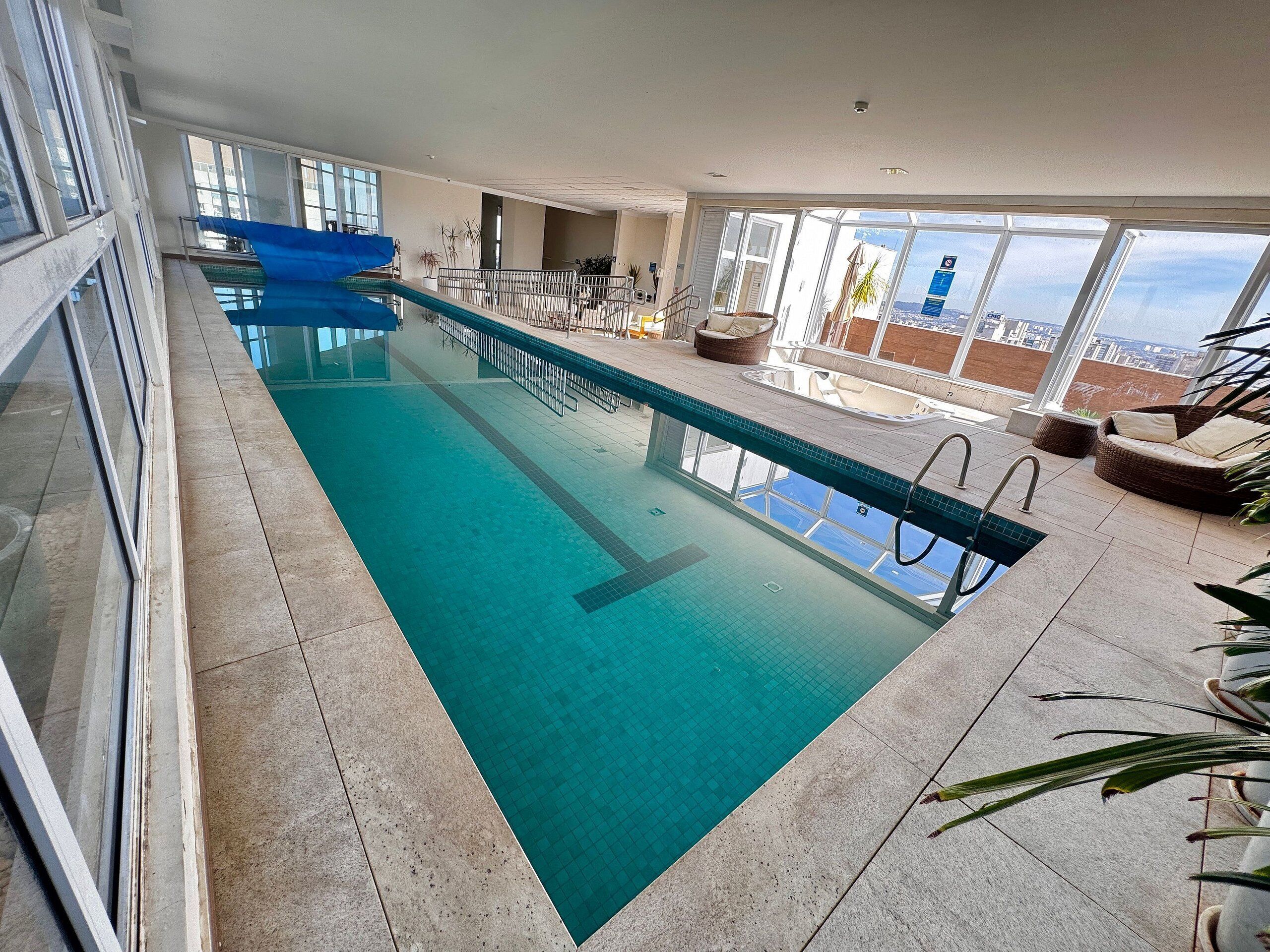 Una piscina al aire libre, sillones reclinables de piscina