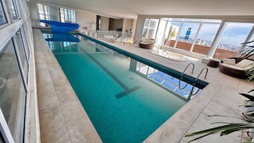 Una piscina al aire libre, sillones reclinables de piscina