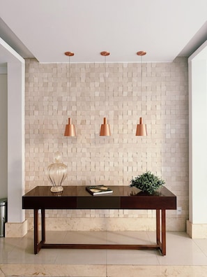 A modern interior with a tiled wall, a wooden table, and three pendant lights.