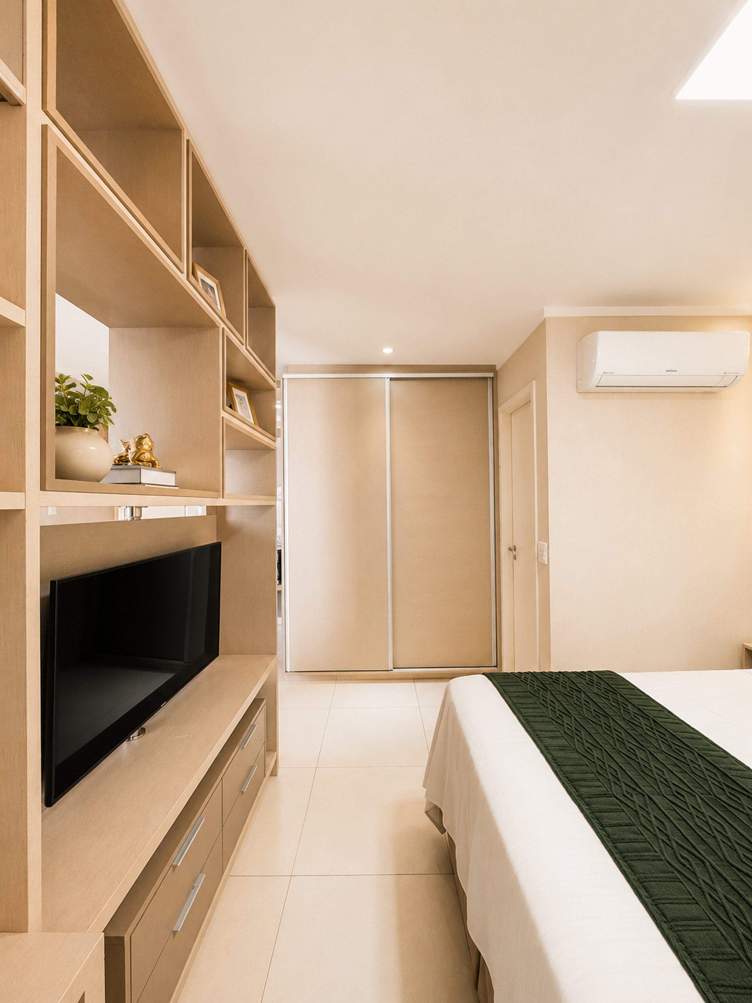 A bedroom with a TV, wardrobe, and air conditioning unit.