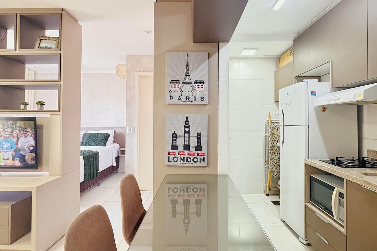 Una cocina moderna con comedor, que incluye un televisor de pantalla plana, un refrigerador y un microondas.