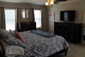 A bedroom with a large bed, two dressers, a television, and a ceiling fan. - Peaceful 4-bedroom house with AC in lovely Loveland (Loveland)