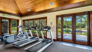 A gym with treadmills, elliptical machines, and a stone wall. - Mauna Lani Townhome w/ Golf Course Views Beach Club Access (Kamuela)