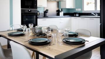 Een moderne keuken met een eettafel voor vier personen, compleet met borden, glazen en bestek.