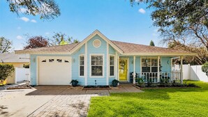 Einbungalow mit Garage, einer Veranda und einem gepflegten Rasen.