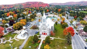 Vue aérienne d’une ville avec une église imposante, une place centrale et des quartiers résidentiels environnants.