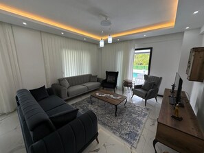A modern living room with a sectional sofa, armchairs, a coffee table, and a TV. - Star villa 1 Spacious 4-bedroom villa in adorable Dalyan with AC (Dalyan)