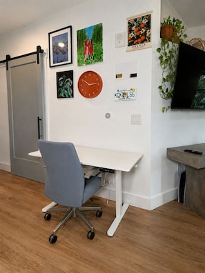 A modern office space with a desk, chair, wall-mounted clock, and various decorative items. - Cozy 1BR Apartment in Atlanta – Prime Location Near Midtown & Downtown (Atlanta)