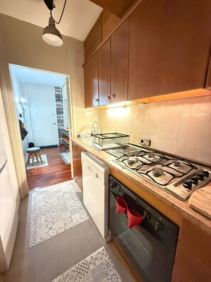 Uma cozinha com fogão, forno e armários.