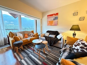 A modern living room with a sofa, armchair, coffee table, and a lamp. - Apartment in La Molina (Alp)