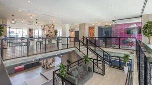 Ein geräumiger Innenbereich mit einer Galerieebene, modernen Leuchten und einer Treppe.