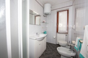 Ein Badezimmer mit Waschbecken, Bidet, Toilette und Spiegel.