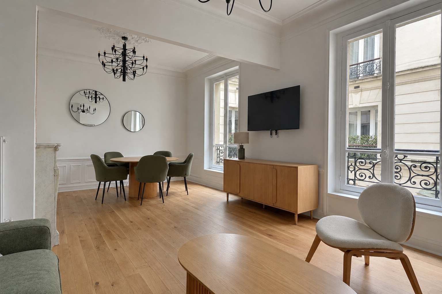 A modern living room with a dining area, a flat-screen TV, and large windows.
