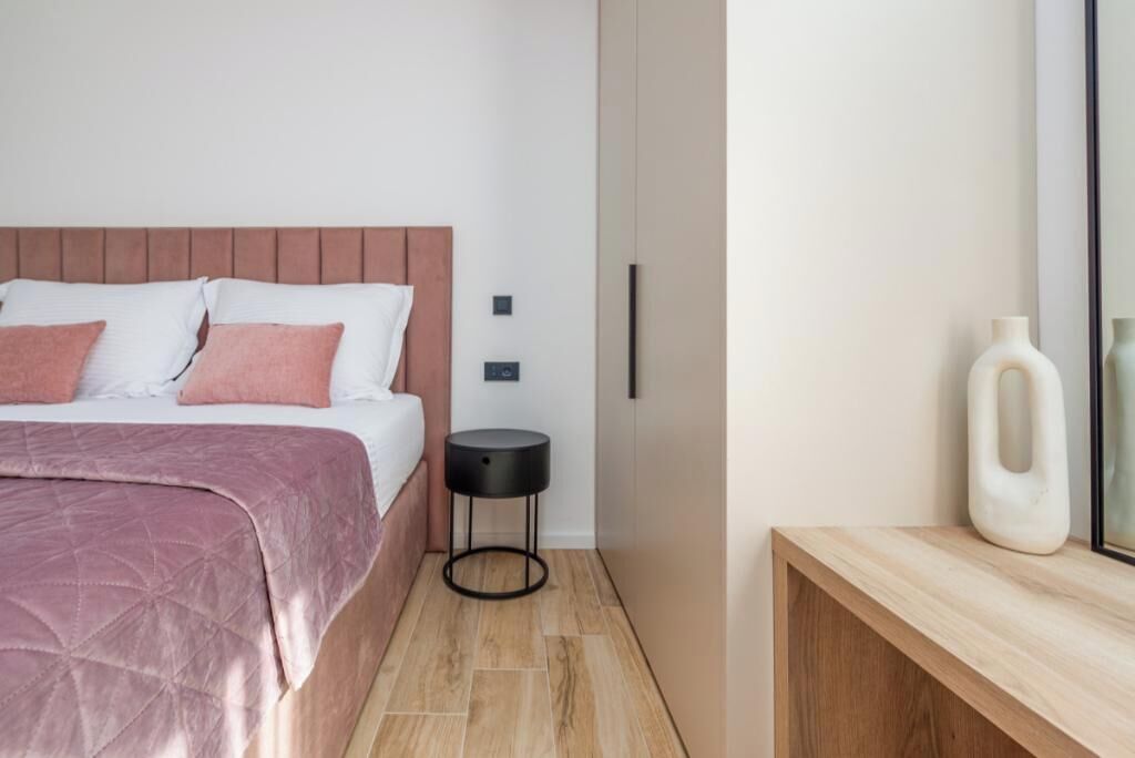 A modern bedroom with a bed, bedside table, and a wooden console.