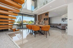 Een modern interieur met een eethoek, een bank en een trap.