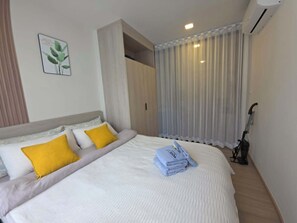Ein Hotelzimmer mit Bett, einem Vorhangfenster, einer Klimaanlage und einem Staubsauger.