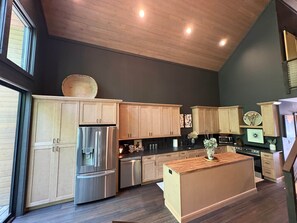A modern kitchen with wooden cabinets, stainless steel appliances, and a central island. - Blackwood Retreat Cabin Hendersonville, NC (Henderson County)