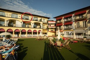 Ein Hotelinnenhof mit Außenmöbeln, einem Pool und einem weißen Zaun.