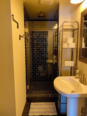 Kylpyhuone, jossa on suihku, wc, pesuallas ja peili.