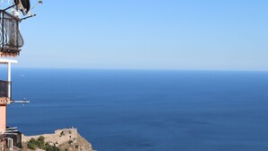 A coastal town with a clear view of the sea, a parking area with several cars, and buildings with balconies overlooking the ocean. - Villa Flavio-Panoramic Boutique Rooms  (Castelmola)