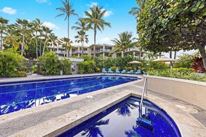 A swimming pool with blue tiles, surrounded by palm trees and lounge chairs. - Includes Beach Gear!  E305 Vista Waikoloa (Waikoloa)