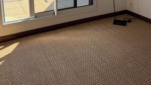 Una habitación con un gran ventanal corredero que da a un balcón, una lámpara de pie y piso alfombrado.