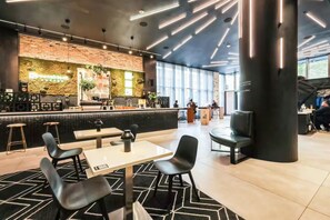 A modern coffee shop with a bar area, seating, and a large pillar. - Infinity Pool - Modern Luxury - Spacious 2BR - Gym (Miami)