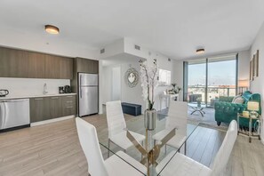 A modern apartment with a kitchen, dining area, and living room. - Infinity Pool - Modern Luxury - Spacious 2BR - Gym (Miami)