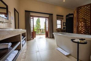 Un bagno d'hotel con una vasca, un lavabo e un'ampia finestra.